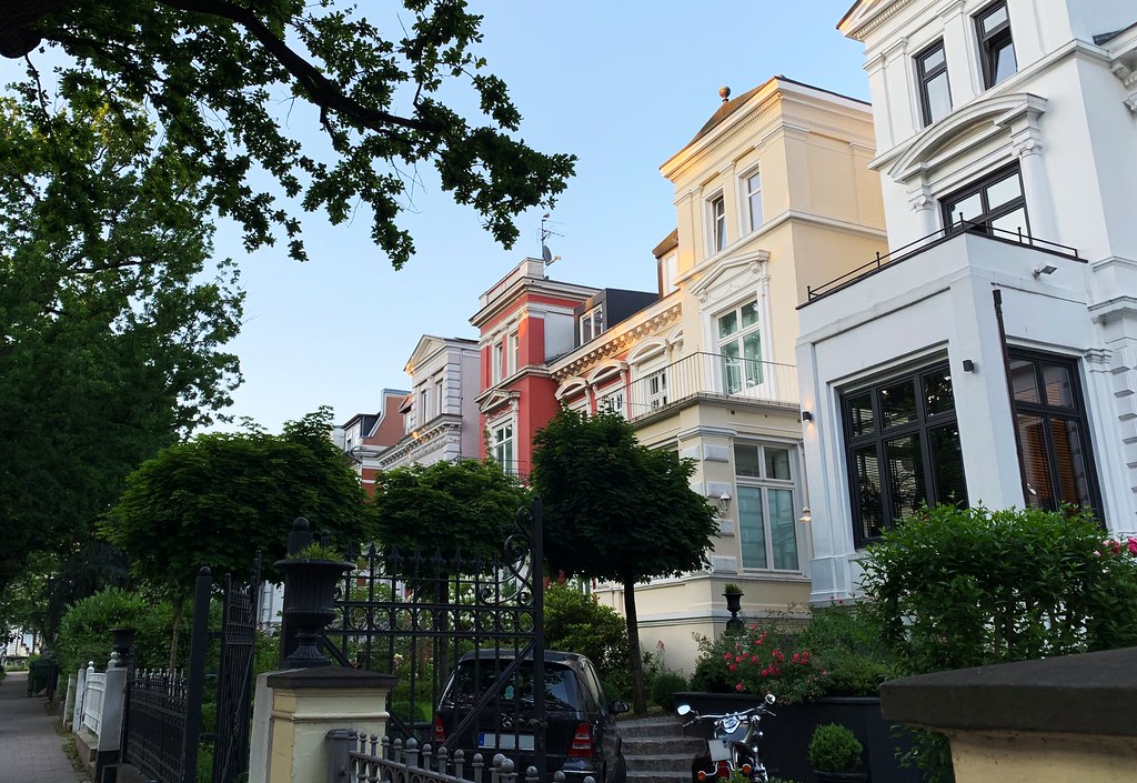 man in black shirt sitting on chair near white wooden house during daytime